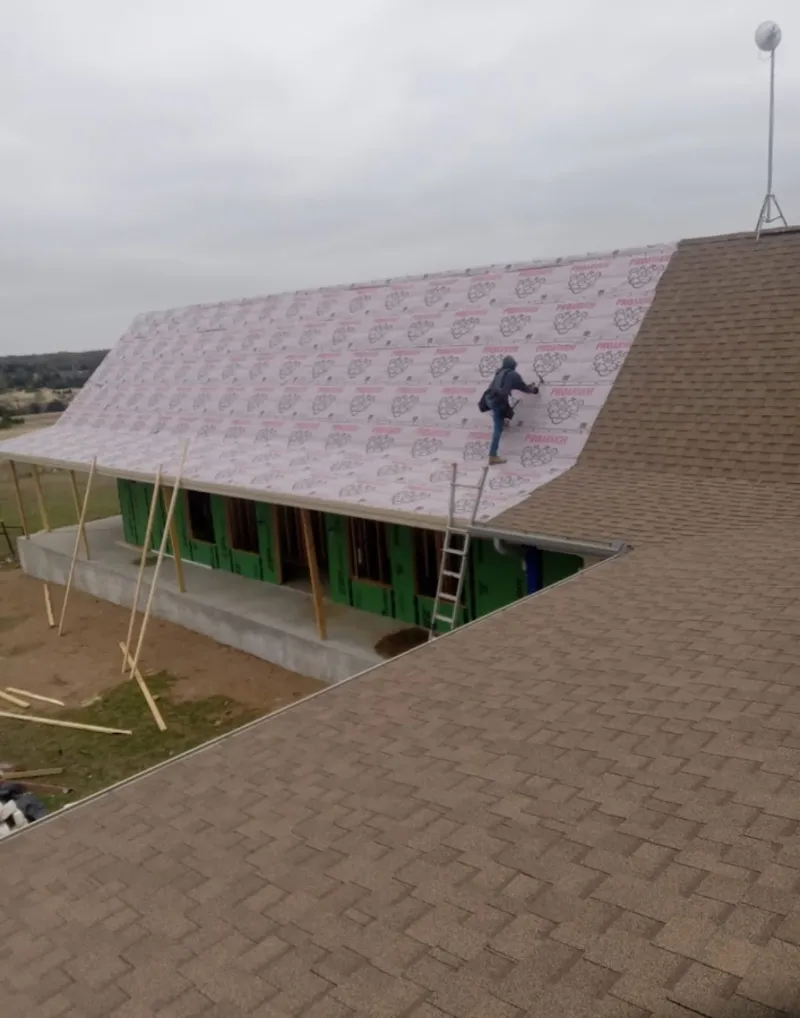 Worker preparing underlayment for a metal roof installation in Bethel Park